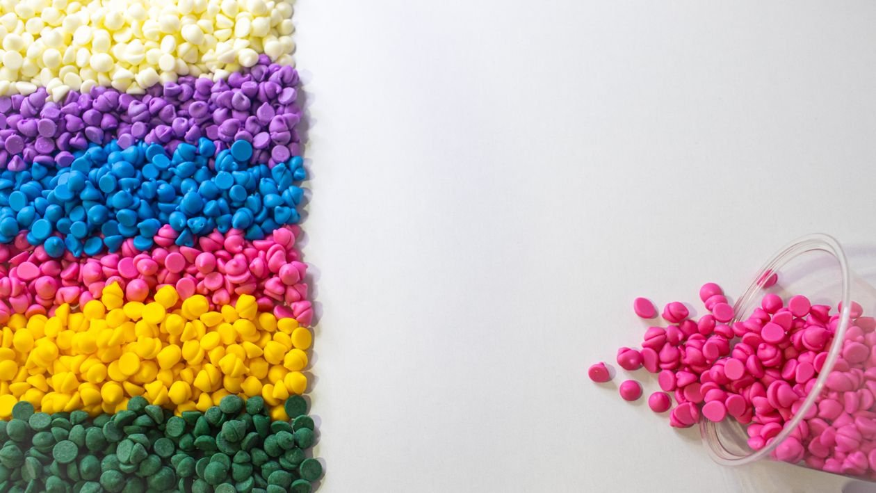 Colourful plastic polymer granules on a white background